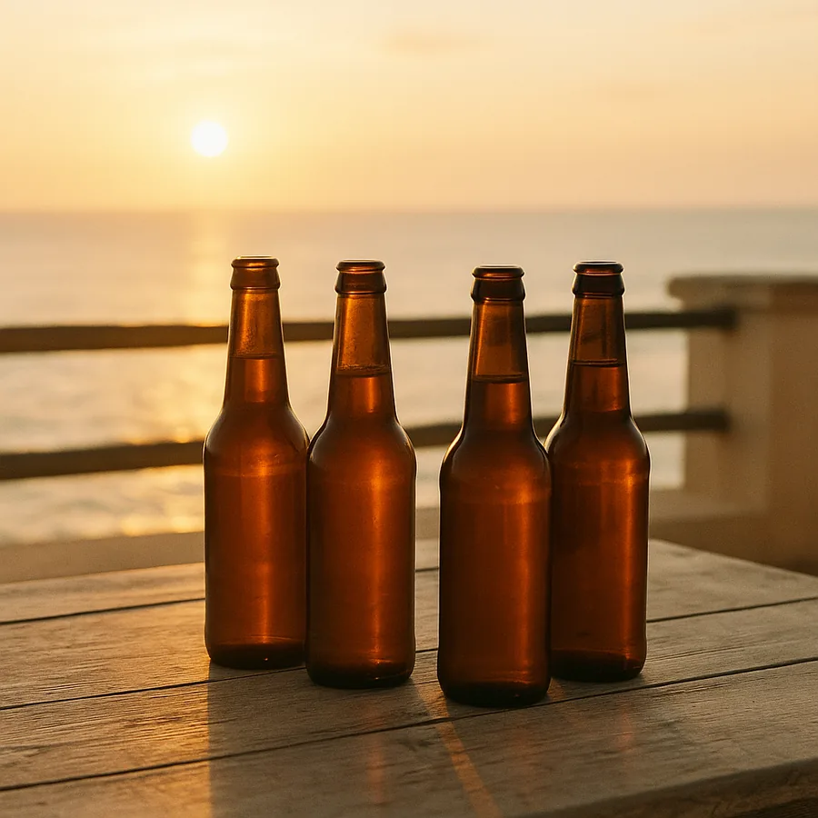Bottles of beer on a table overlooking the water at sunset